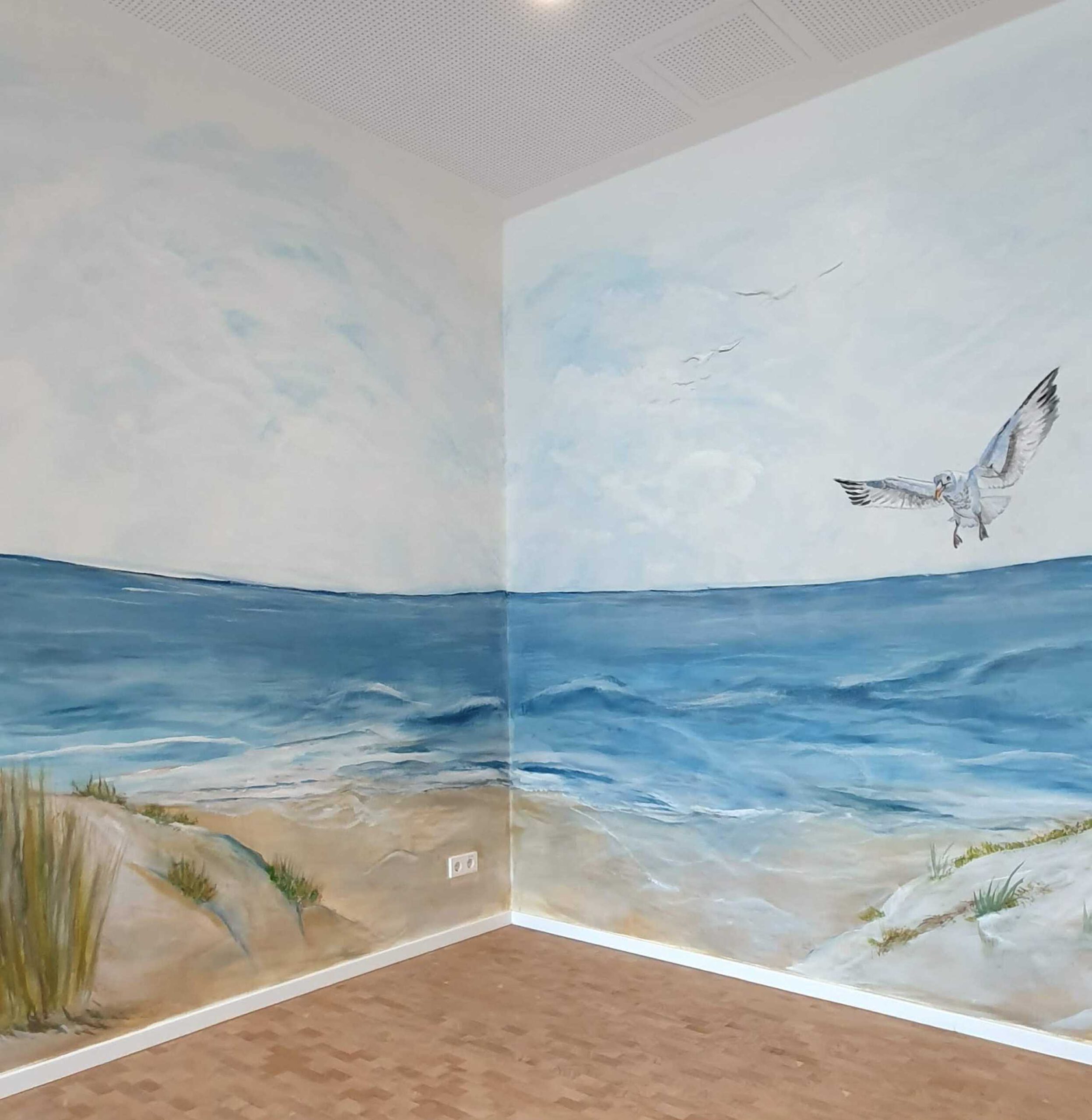 Zwei Wände über Eck, die mit einer Meerlandschaft an der Nordsee bemalt sind. Rechst oben fliegt eine Möwe auf den Betrachter zu.
